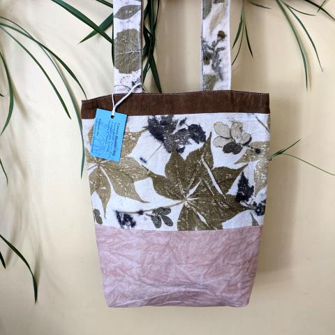 Naturally dyed tote bag hanging on a wall