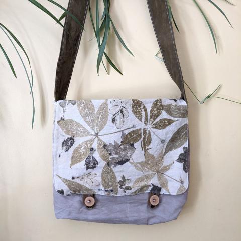 Eco-printed messenger bag hanging on a wall