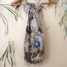 Eco-printed scarf hung on a wall amongst some spider plants